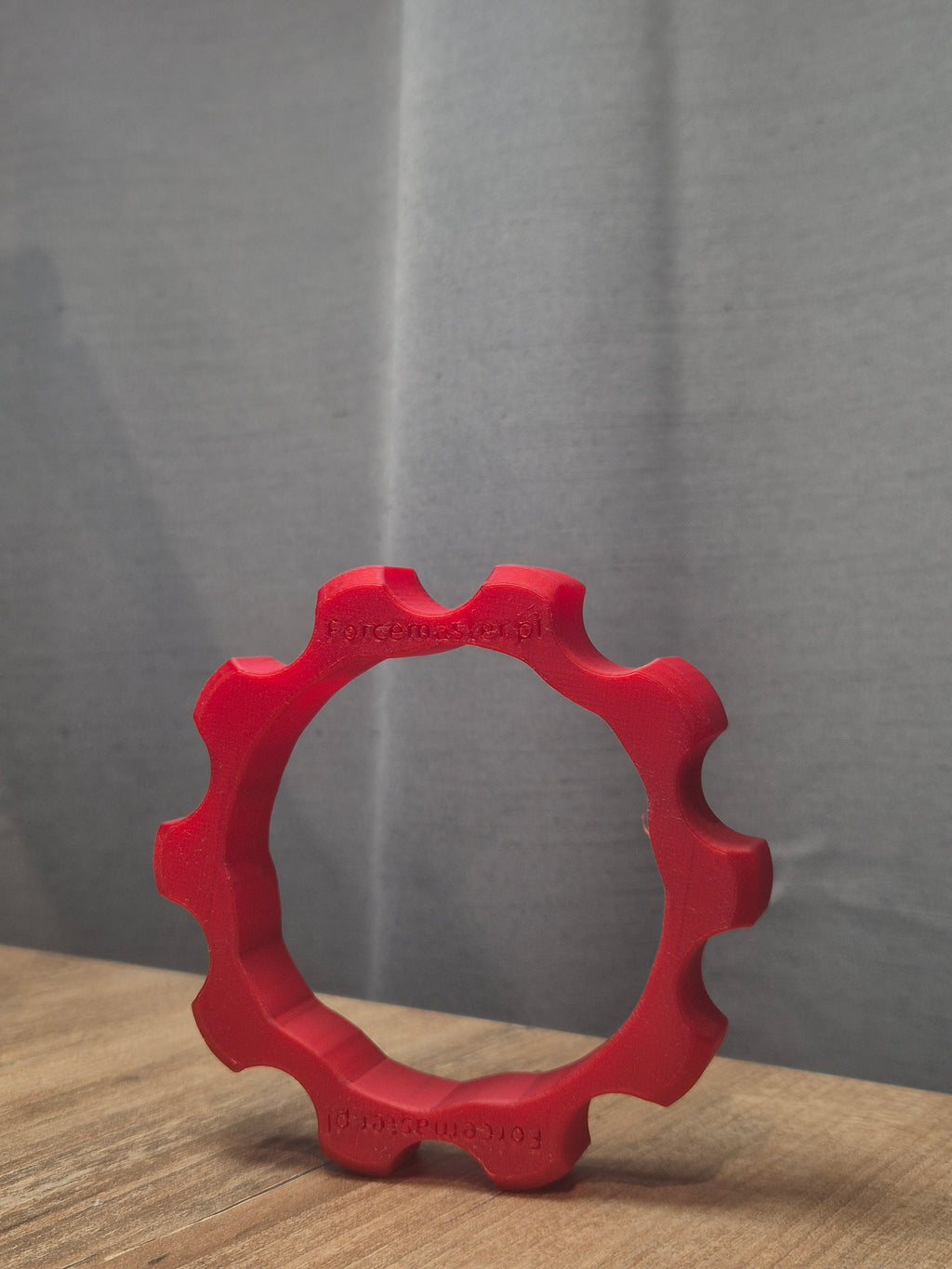 Czerwony adapter Quick Release Forcemaster na biurku, wykonany z wytrzymałego materiału w druku 3D.