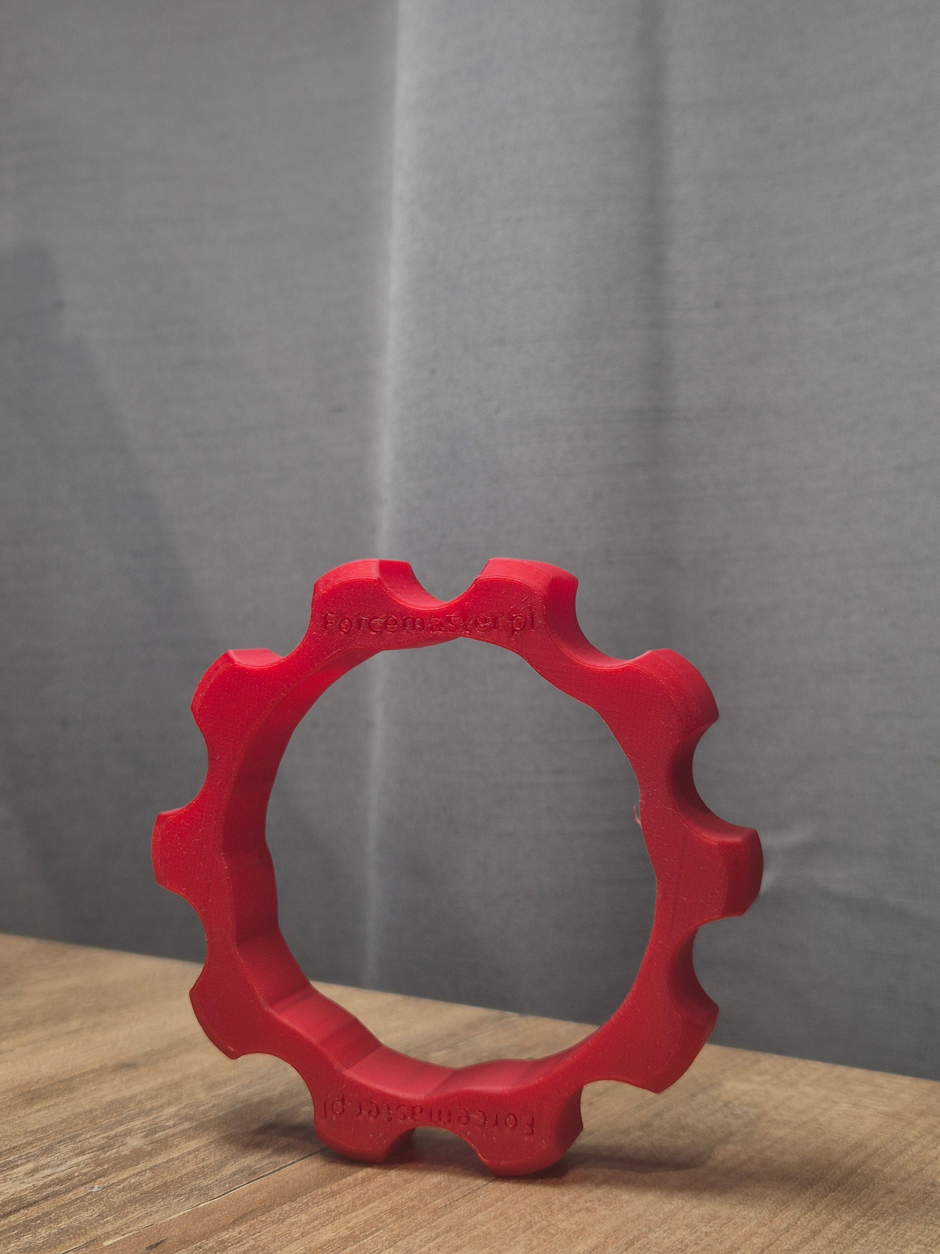 Czerwony adapter Quick Release Forcemaster na biurku, wykonany z wytrzymałego materiału w druku 3D.