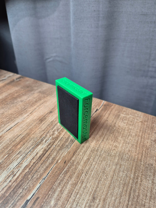 Spód zielonej blokady Forcemaster z widoczną czarną gumową podkładką antypoślizgową zapobiegającą rysowaniu paneli i płytek.