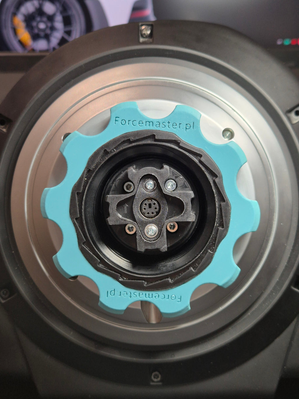 urkusowy adapter Quick Release Forcemaster zamontowany na bazie Thrustmaster, ułatwiający szybką wymianę obręczy.