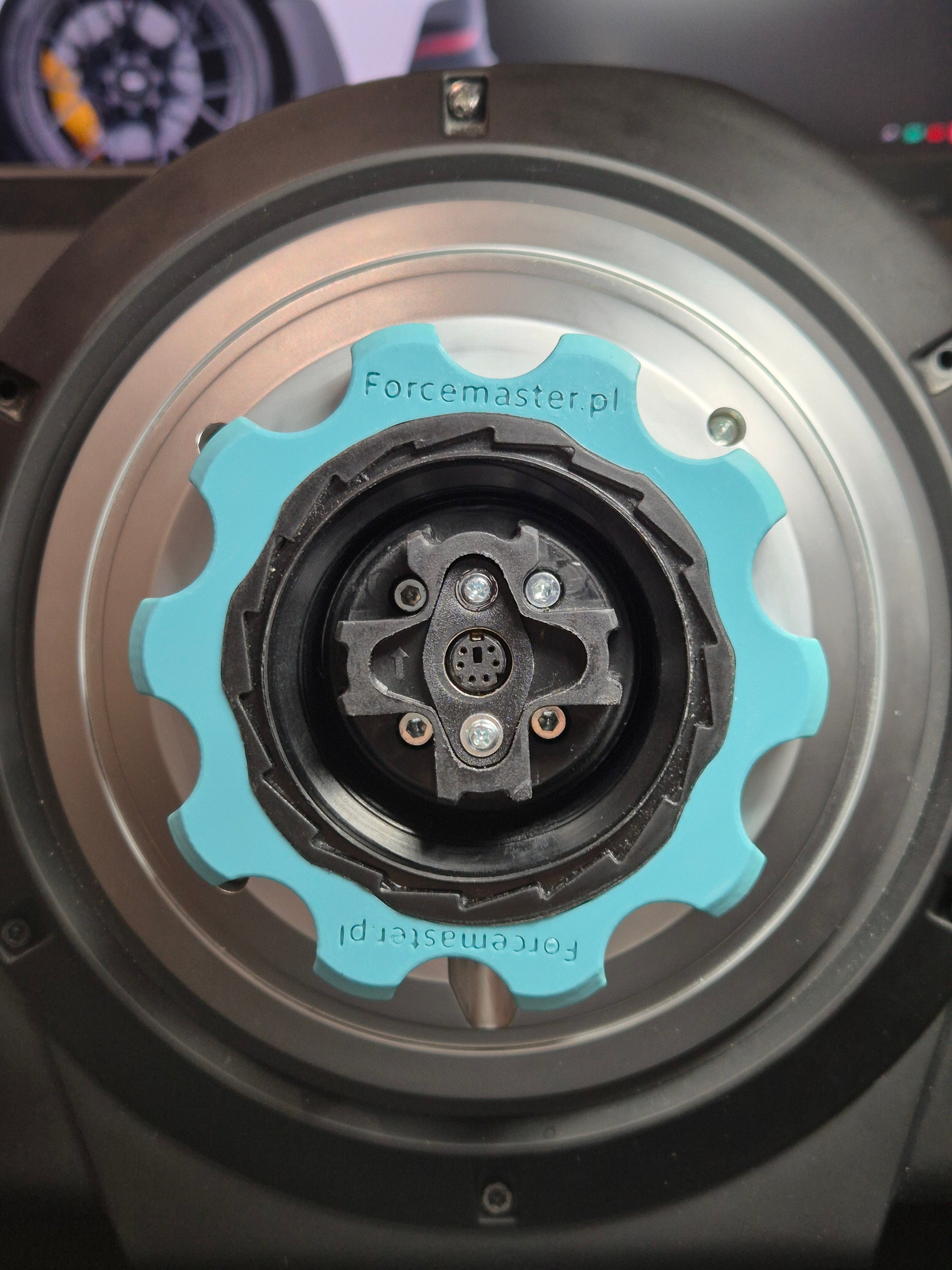urkusowy adapter Quick Release Forcemaster zamontowany na bazie Thrustmaster, ułatwiający szybką wymianę obręczy.
